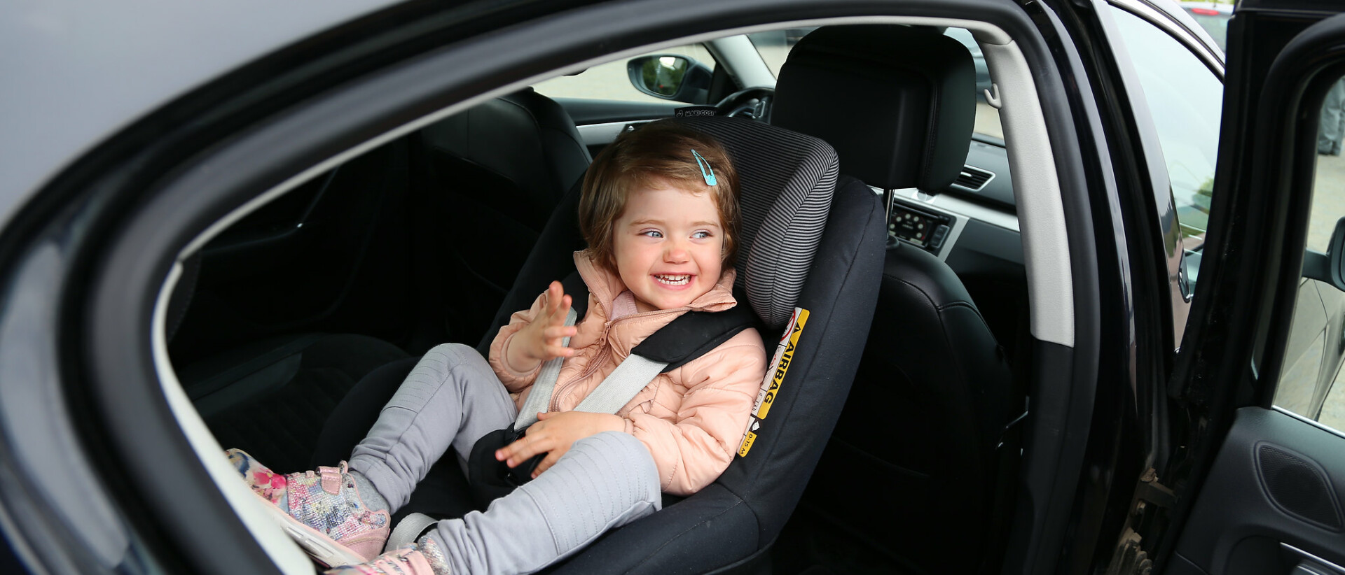 Pieni lapsi istuu autossa turvaistuimessa selkä menosuuntaan.
